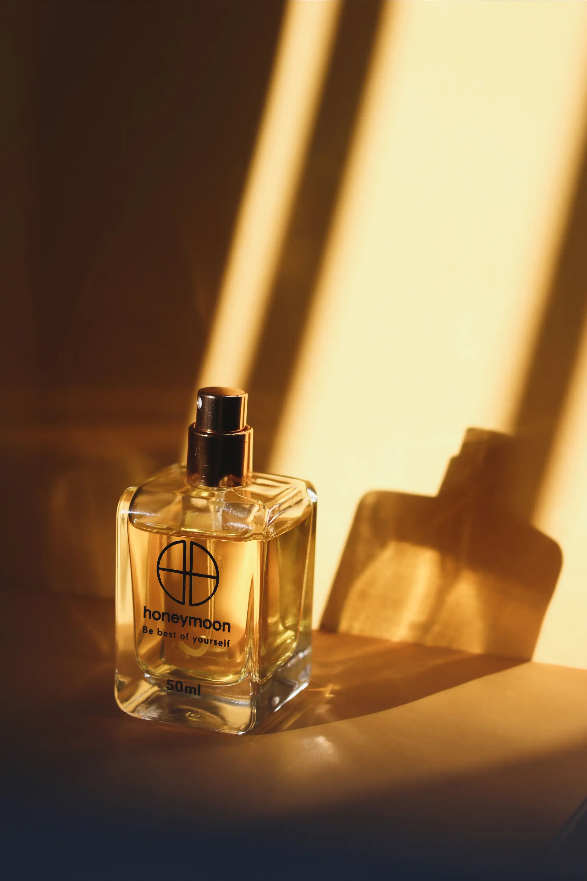 Minimalist glass fragrance bottle casting soft shadows in natural light