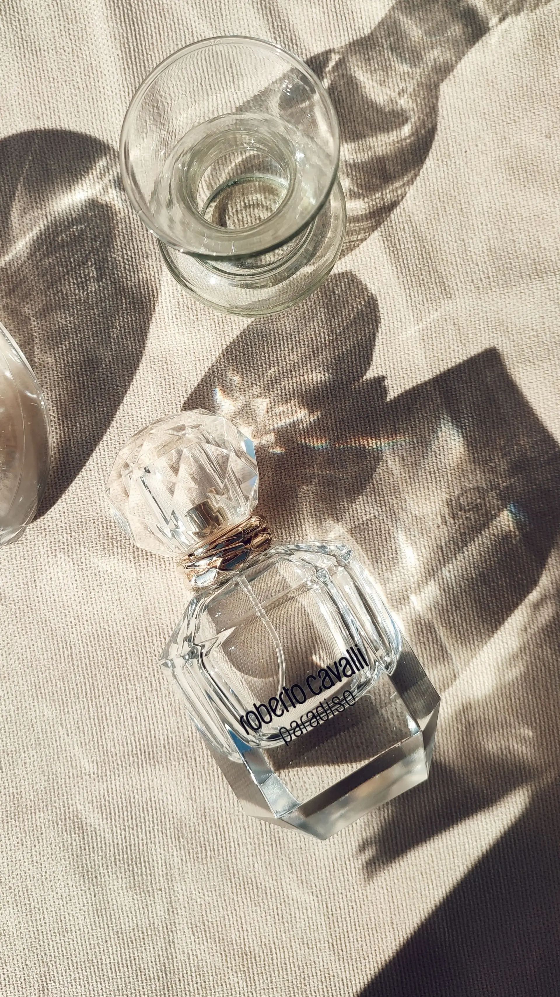 Sunlight casting shadows on a luxurious perfume bottle